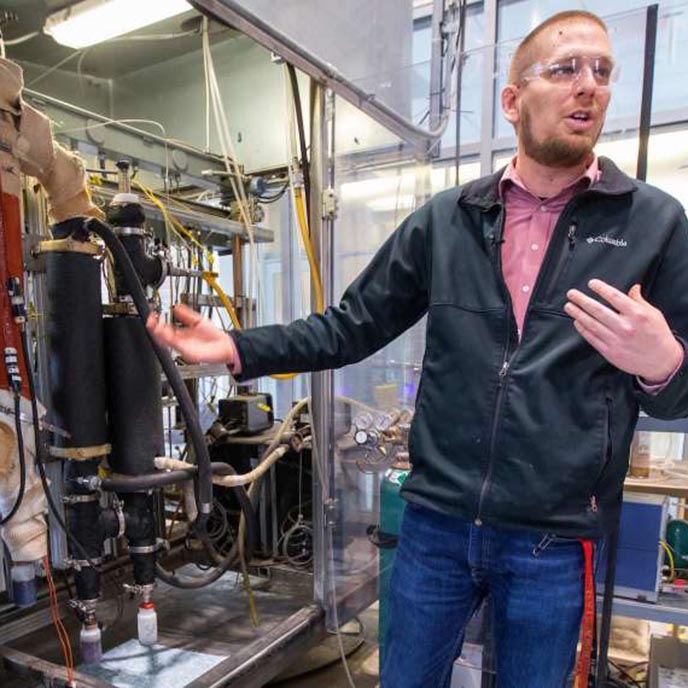 Tannon Daugaard, an engineer at the Bioeconomy Institute, with the pilot-scale pyrolyzer at the Biorenewables Center.