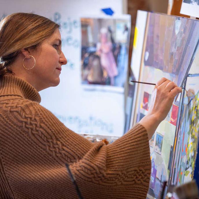 Jennifer Drinkwater, associate professor of art and visual culture and community arts specialist for ISU Extension and Outreach, paints in her studio in downtown Ames.